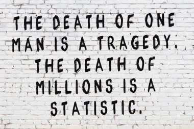 Beyaz tuğla duvara zekice alıntılar yazılı siyah bir yazı.