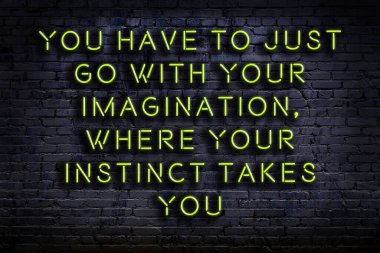 Tuğla duvardaki bilgece alıntıların neon yazıları üzerine gece görüşü