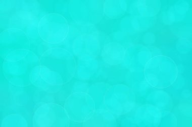 Çember şeklindeki bokeh noktalarıyla mavi ve yeşil soyut odaklanmış arkaplan