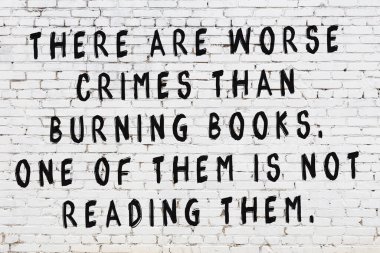 Üzerinde mantıklı alıntıların yazılı olduğu siyah boyanmış beyaz tuğla duvar.