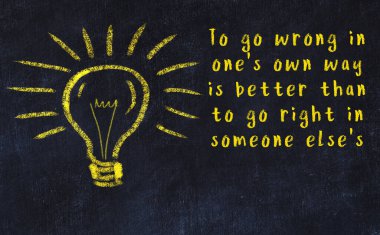 Bir karatahtaya ve bir ampul çizimine elle yazılmış akıllı bir alıntı.