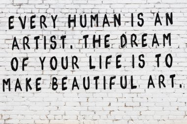 Beyaz tuğla duvar ve bilgece alıntıların yazılı olduğu siyah yazı.