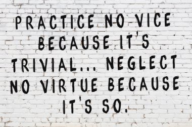 Üzerinde mantıklı alıntıların yazılı olduğu siyah boyanmış beyaz tuğla duvar.