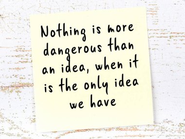 Tahta duvarda el yazısı motivasyon alıntısı olan sarı yapışkan not