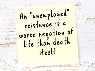 Tahta duvarda asılı sarı yapışkan nota elle yazılmış bilgece bir alıntı.