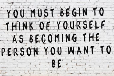 Üzerinde mantıklı alıntıların yazılı olduğu siyah boyanmış beyaz tuğla duvar.