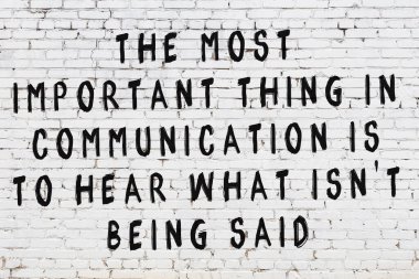 Üzerinde mantıklı alıntıların yazılı olduğu siyah boyanmış beyaz tuğla duvar.