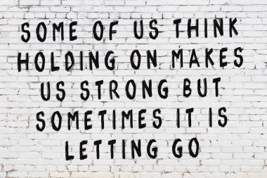 Üzerinde mantıklı alıntıların yazılı olduğu siyah boyanmış beyaz tuğla duvar.