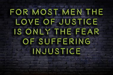 Tuğla duvardaki bilgece alıntıların neon yazıları üzerine gece görüşü