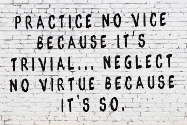 Üzerinde mantıklı alıntıların yazılı olduğu siyah boyanmış beyaz tuğla duvar.