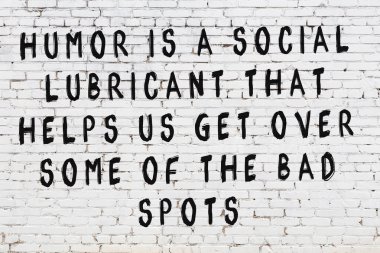 Beyaz tuğla duvar ve bilgece alıntıların yazılı olduğu siyah yazı.