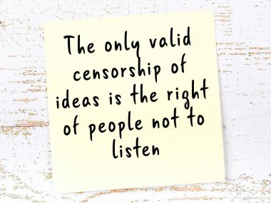 Tahta duvarda asılı sarı yapışkan nota elle yazılmış bilgece bir alıntı.