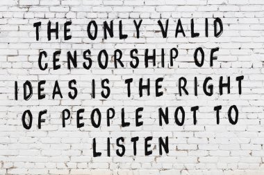 Beyaz tuğla duvar ve bilgece alıntıların yazılı olduğu siyah yazı.