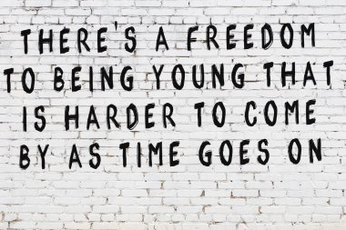 Beyaz tuğla duvara zekice alıntılar yazılı siyah bir yazı.