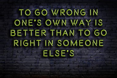 Tuğla duvardaki ışıklı neon tabela olarak bilgece alıntı