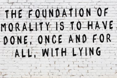 Üzerinde mantıklı alıntıların yazılı olduğu siyah boyanmış beyaz tuğla duvar.