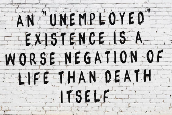 Beyaz tuğla duvara zekice alıntılar yazılı siyah bir yazı.