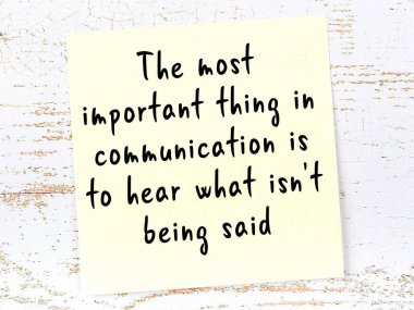 Tahta duvarda el yazısı motivasyon alıntısı olan sarı yapışkan not