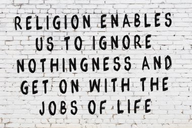 Beyaz tuğla duvara zekice alıntılar yazılı siyah bir yazı.