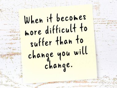 Tahta duvarda el yazısı motivasyon alıntısı olan sarı yapışkan not