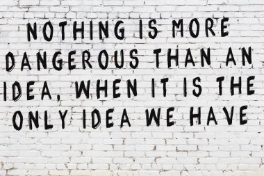 Beyaz tuğla duvar ve bilgece alıntıların yazılı olduğu siyah yazı.