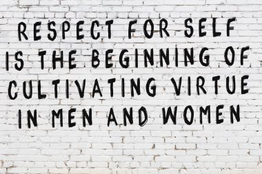 Üzerinde mantıklı alıntıların yazılı olduğu siyah boyanmış beyaz tuğla duvar.