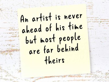 Tahta duvarda asılı sarı yapışkan nota elle yazılmış bilgece bir alıntı.