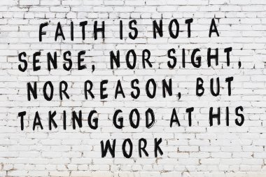 Beyaz tuğla duvara zekice alıntılar yazılı siyah bir yazı.