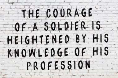 Beyaz tuğla duvar ve bilgece alıntıların yazılı olduğu siyah yazı.