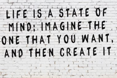 Beyaz tuğla duvar ve bilgece alıntıların yazılı olduğu siyah yazı.