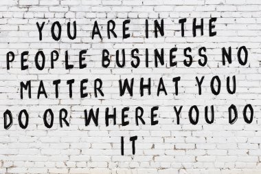 Üzerinde mantıklı alıntıların yazılı olduğu siyah boyanmış beyaz tuğla duvar.