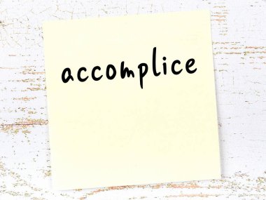 Tahta duvardaki sarı yapışkan notta el yazısıyla yazılmış suç ortağı var.