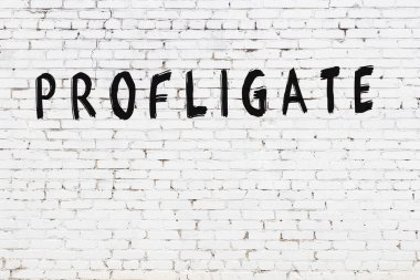 Üzerinde yazı olan beyaz tuğla duvar. Elle yazılmış, siyah boyalı.