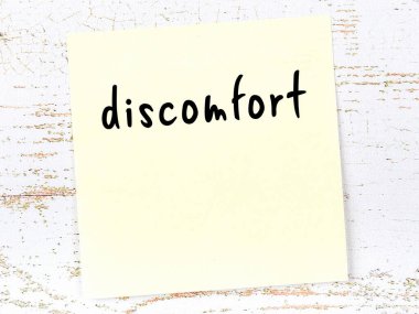 Rahatsızlık hakkında hatırlatma kavramı. Tahta duvarda üzerinde yazı olan sarı yapışkan kağıt.