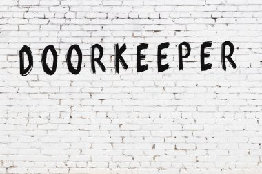 Beyaz tuğladan duvar, siyah boyayla el yazısıyla yazılmış.