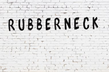 Siyah boyalı, el yazısıyla yazılmış beyaz tuğlalı bir duvar.