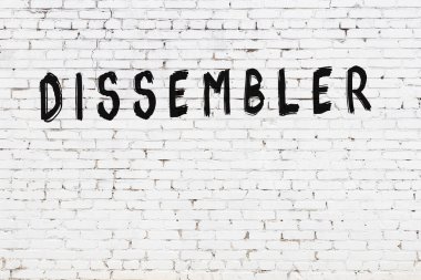 Siyah boyalı el yazısıyla yazılmış beyaz tuğlalı bir duvar.