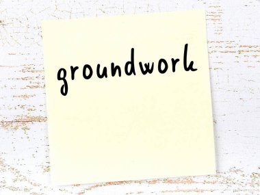 Tahta duvardaki sarı yapışkan notta elle yazılmış altyazı var.