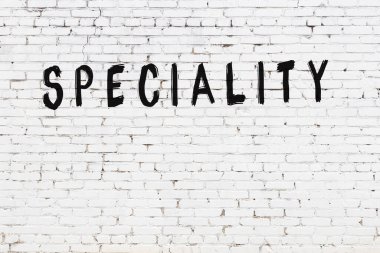 Üzerinde siyah boya bulunan beyaz tuğla bir duvar.