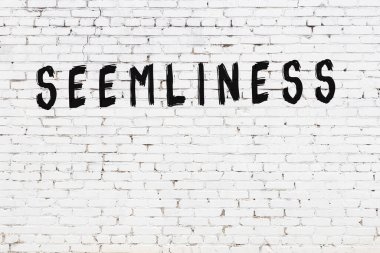 Yazı uygunluğu beyaz tuğla duvara siyah boya ile yazılmış..