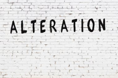 Siyah boyayla el yazısıyla yazması değiştirilmiş beyaz tuğla duvar.