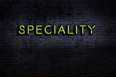 Tuğla duvara karşı özel yazıtlı neon tabela. Gece görünümü