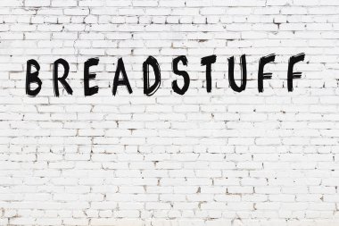 Beyaz tuğla duvarda siyah boyayla yazılmış bir yazı..