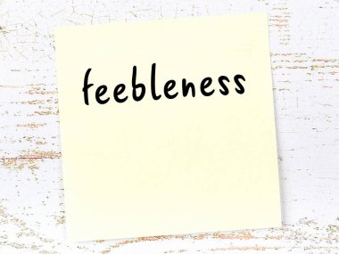 Tahta duvardaki sarı yapışkan notta el yazısıyla yazılmış zayıflık var.