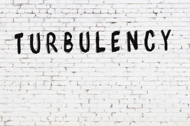 Beyaz tuğladan duvar, yazı türbülansı, el yazısıyla siyah boya.