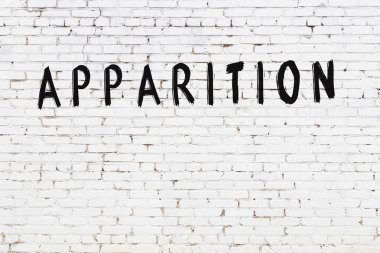 Siyah boyayla yazılmış beyaz tuğlalı bir duvar.