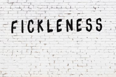 Üzerinde yazı olan beyaz tuğla duvar. Siyah boyayla yazılmış.