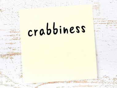 Ahşap duvardaki sarı yapışkan notta el yazısıyla yazılmış huysuzluk var.