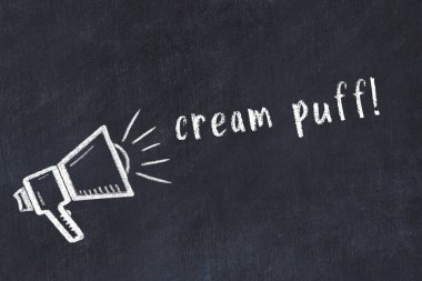 Hoparlör çizimli siyah karatahta ve kremalı pasta.