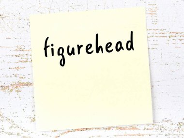 Figüran hakkında hatırlatma kavramı. Tahta duvarda üzerinde yazı olan sarı yapışkan kağıt.